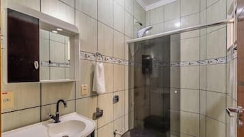 Ein Badezimmer mit Waschbecken, Spiegel und Duschkabine.