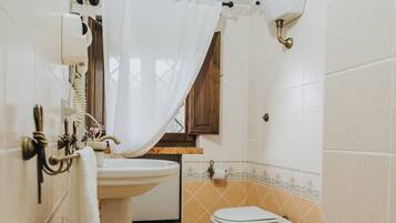 Une salle de bain équipée d’un lavabo, de toilettes et d’un rideau de douche.