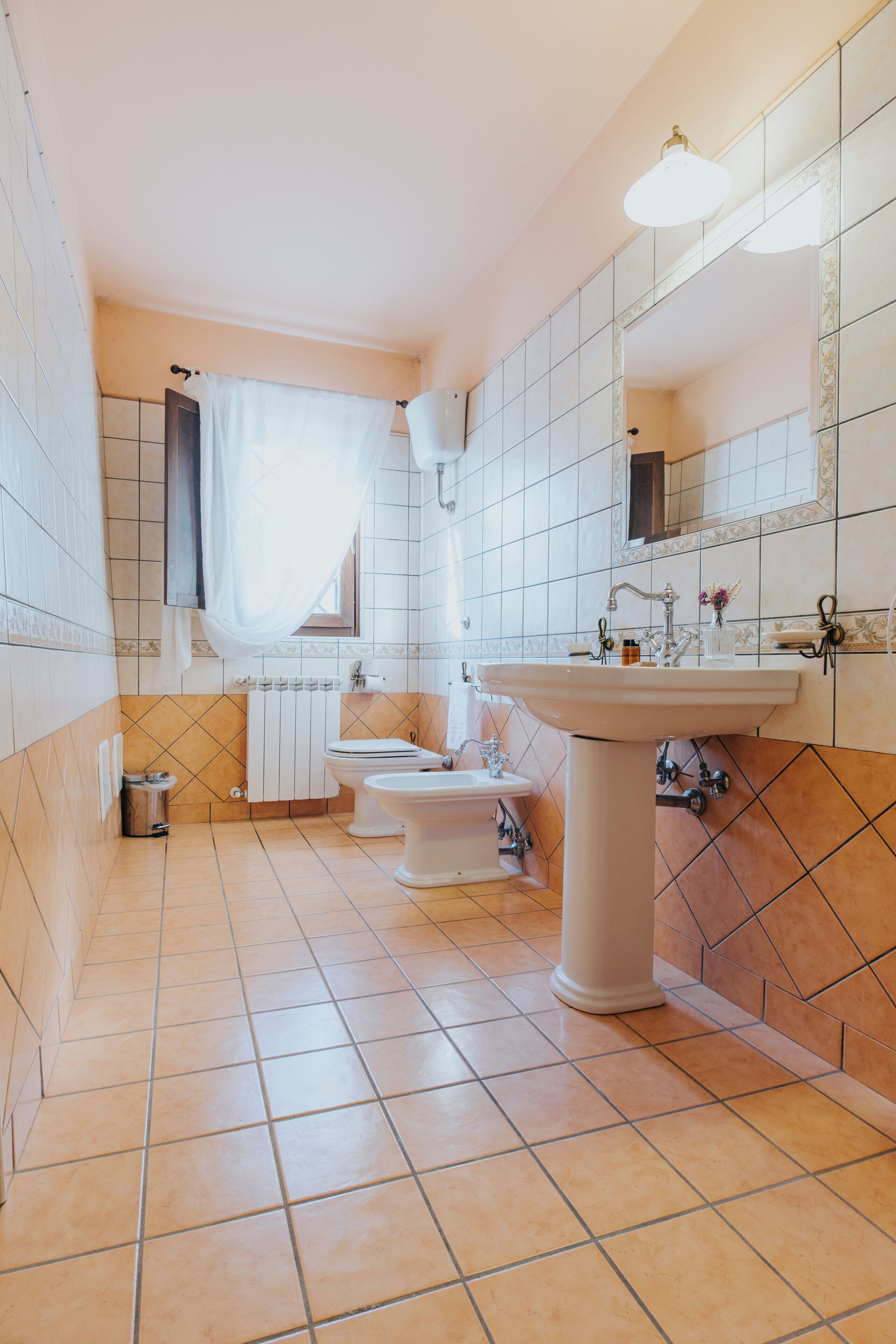 A bathroom with a sink, toilet, and bidet.