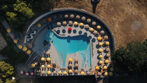 An aerial view of a swimming pool area with multiple sun loungers and umbrellas. - Villaggio Rurale Le Sette Querce (Sesto Campano)