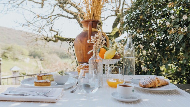 A table set for breakfast with a croissant, orange juice, and a fruit bowl. - Villaggio Rurale Le Sette Querce (Sesto Campano)