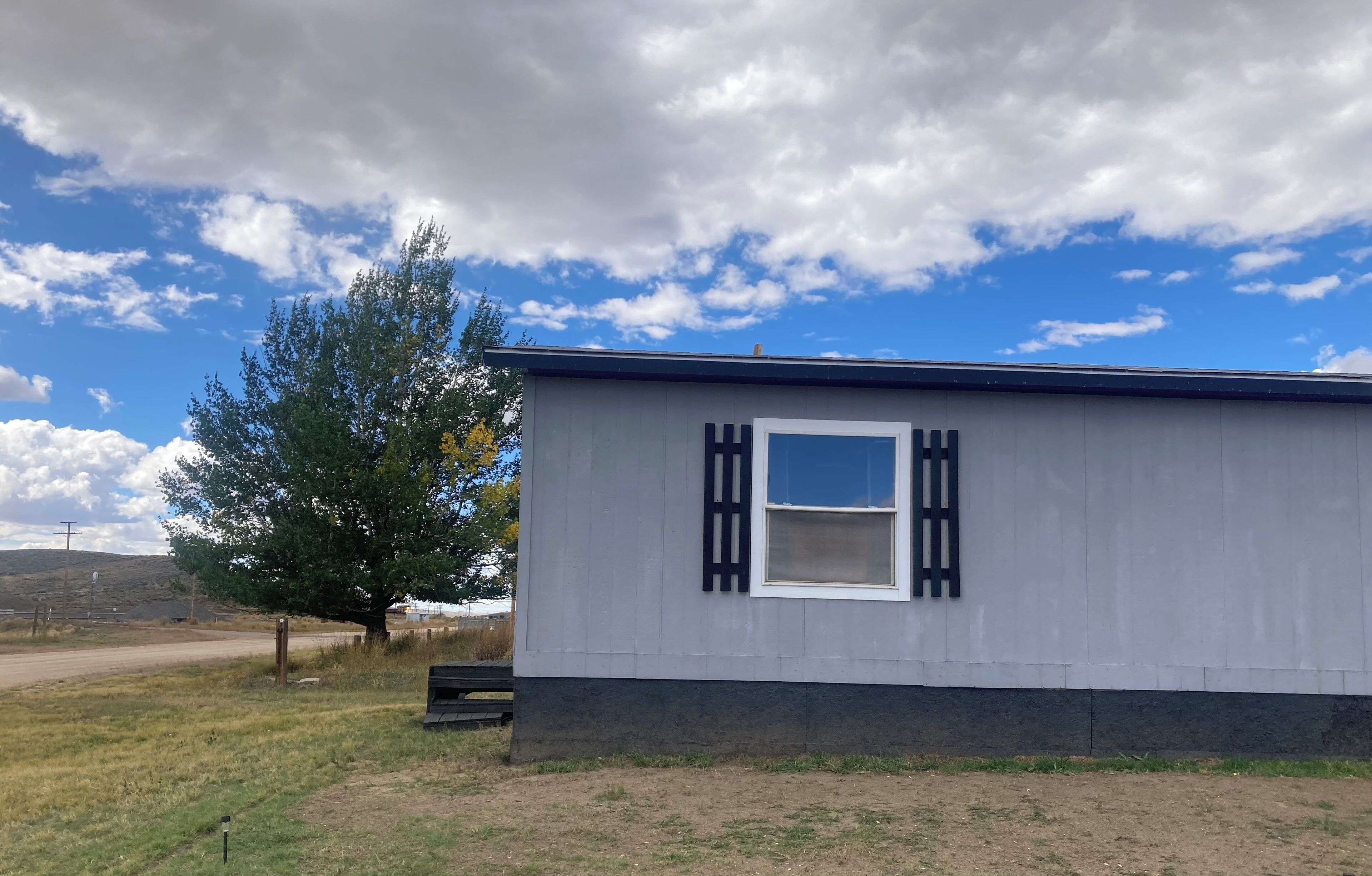 A single-story building with a white exterior and a black window frame.