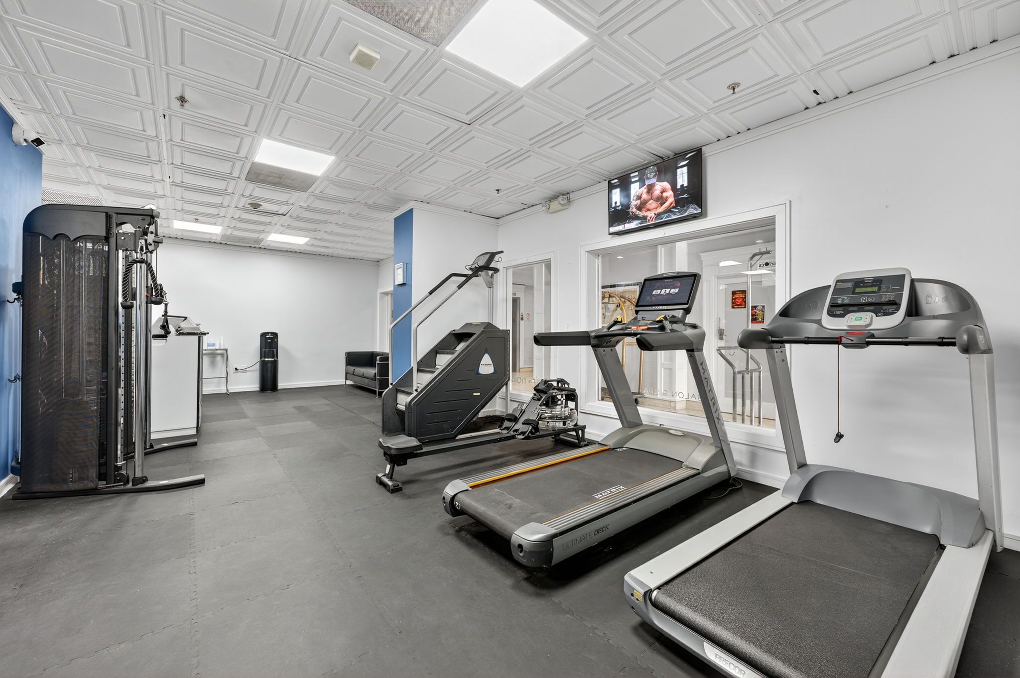 A gym with treadmills, a stair climber, and weight machines.