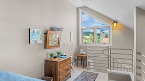 A bedroom with a wooden dresser, a mirror, a small table with a plant, a rug, and a staircase. - Blue Mesa Lodge 40A by Avantstay Ski In/ Ski Out Unit w/ Balcony! (Telluride)