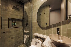 A bathroom with a glass-enclosed shower, a toilet, a sink with a large basin, and a mirror. - 10th Street 3 Bedroom Jacuzzi & Billiard (Medellín)