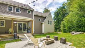A patio with outdoor furniture, a fire pit, and a stone wall. - Spacious home,ppong,darts,pick ball net, 6mi mt sn (Wilmington)