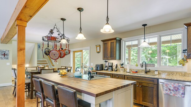 A spacious kitchen with a large island, wooden bar stools, and pendant lighting. - Spacious home,ppong,darts,pick ball net, 6mi mt sn (Wilmington)