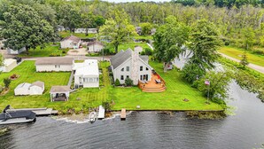A lakeside house with a dock, a boat, and a well-maintained lawn. - Garage Game Room, Bar: Coldwater Lake House! (Coldwater)