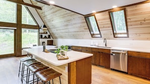 A modern kitchen with a large island, wooden ceiling, and large windows. - 1 Mi to Resort Beach: Alpine Lake A-Frame! (Terra Alta)