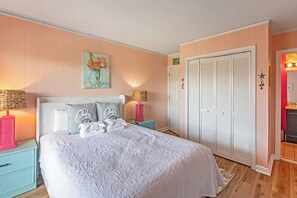 A bedroom with a bed, two bedside tables, a wardrobe, and a painting on the wall. - 2BR Mariners Cove - Pool-Steps to Beach-3rd Floor (Myrtle Beach)