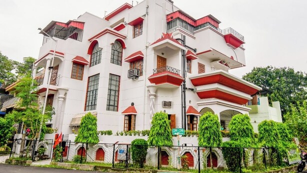 Un immeuble à plusieurs étages, doté d’une façade blanche, de touches de couleur rouge et de nombreux balcons.