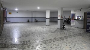 Un vaste espace intérieur doté d’un sol carrelé, de piliers et d’un comptoir d’accueil.