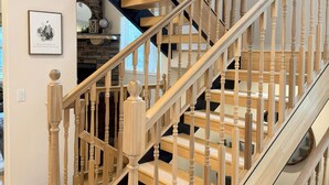Un escalier en bois, doté d’une rampe et orné d’un cadre avec une image accrochée au mur.