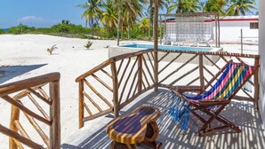 A beachside patio with a hammock, wooden furniture, and a pool area. - LAMAU-Beachfront House, San Crisanto, Yuc. (San Crisanto)