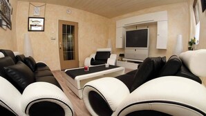 Un salon moderne comprenant un canapé, une table basse, un téléviseur et une porte.
