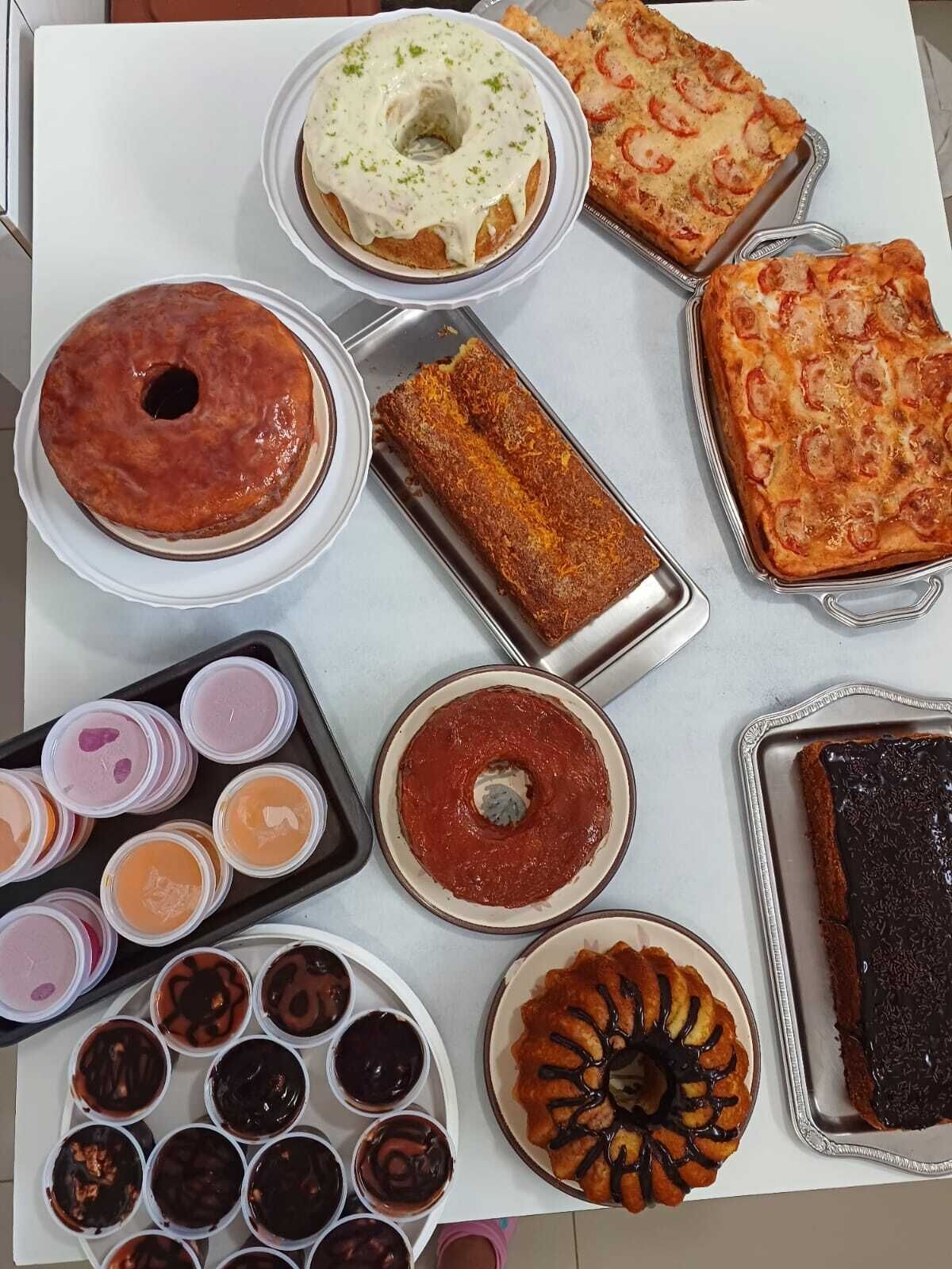 Variedad de postres, incluyendo pasteles, tartas y repostería, dispuestos sobre una mesa.