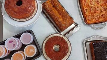 Variedad de postres, incluyendo pasteles, tartas y repostería, dispuestos sobre una mesa.