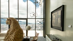 Una habitación con un ventanal grande, un globo terráqueo y un cuadro en la pared.