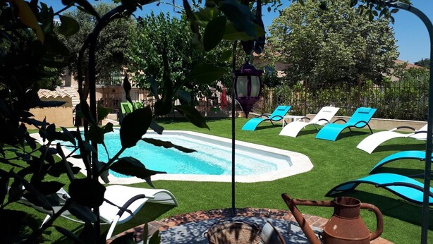 A pool area with a hot tub, lounge chairs, and a pergola. - Maison provençale Coeur du Var (first floor) (GONFARON)