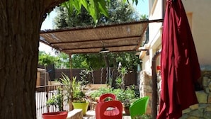 A patio area with a pergola, outdoor furniture, and potted plants. - Maison provençale Coeur du Var (first floor) (GONFARON)