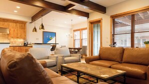 A spacious living room with a brown leather sofa, a coffee table, and a dining area with a wooden table and chairs. - Spacious 4BR home in Steamboat Springs, perfect for family getaways! (Steamboat Springs)