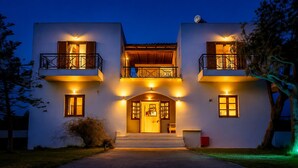 A two-story building with a central entrance, balconies, and a satellite dish. - Charming 1 triple-bedroom  in quaint Georgioupoli with AC (Georgioupoli)