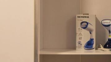 Una estantería blanca con una caja etiquetada 'MONDIAL' y un secador azul.