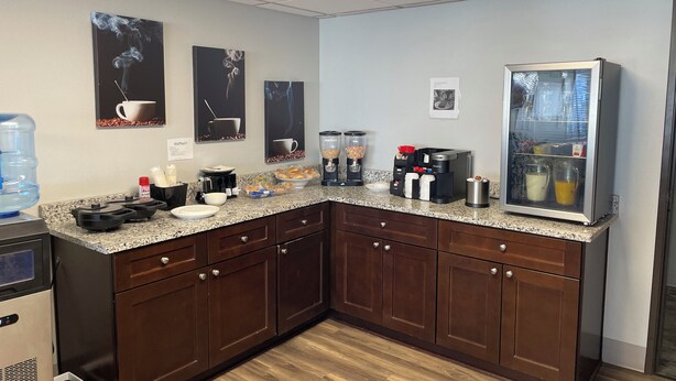 A modern kitchen with granite countertops, stainless steel appliances, and a coffee station. - Lincoln Hotel - King Deluxe (Lincoln)