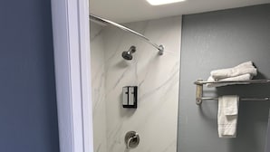 A modern bathroom with a bathtub, toilet, and shower. - Airport Motor Inn (Jacksonville)