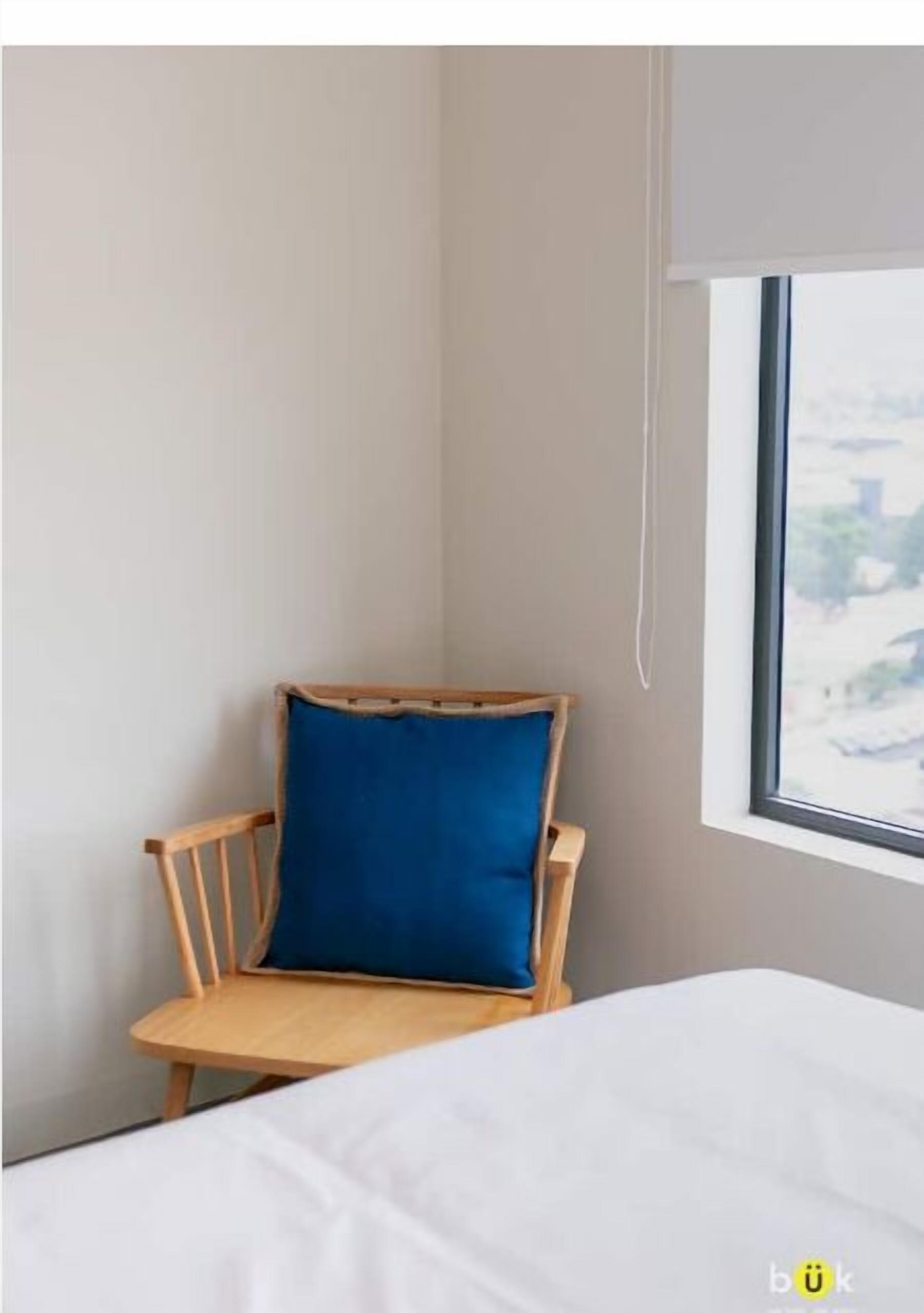 Ein Eckzimmer mit einem Holzstuhl und einem Bett.