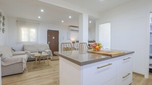 Un apartamento moderno con isla de cocina, comedor y sala de estar.