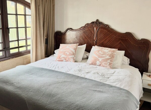 A bed with a wooden headboard, white bedding, and patterned pillows. - Aragon 0861 apartments (Temuco)