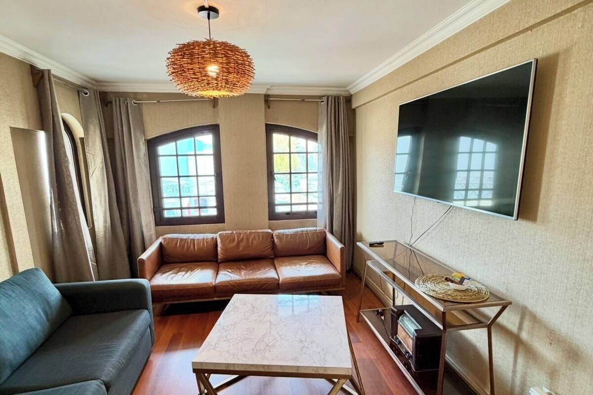 Ein Wohnzimmer mit einer Couch, einem Couchtisch, einem Fernseher und einem Kamin.