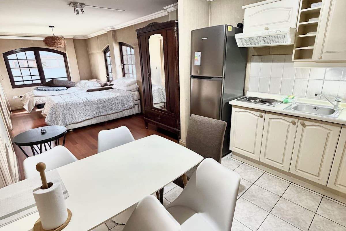 Ein gemütlicher Wohnbereich mit Küchenzeile, Essbereich und Schlafzimmer.