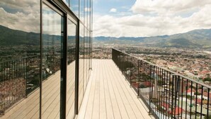 A balcony with a view of a cityscape and mountains.