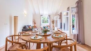 A dining area with a round wooden table set for six, surrounded by six wooden chairs. - Villa Blue Cane with a pool and ping-pong table, perfect for families (Le MOULE)