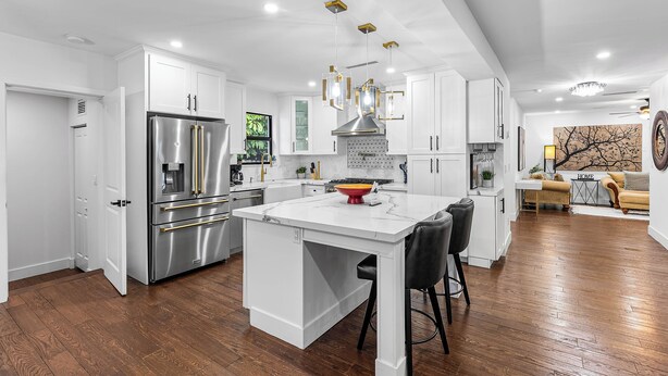 A modern kitchen with white cabinetry, stainless steel appliances, and a central island. - Lux•PrimeLocation•HtdResortPool•OutdrDining (West Palm Beach)