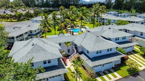 A residential area with multiple houses, a swimming pool, and lush greenery. - Beautiful 2bdrm Condo Facing Lawn, Pool & Hot Tub! (Princeville)