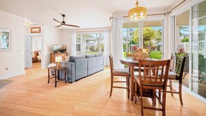 A spacious living area with a dining table, sofa, and ceiling fan. - Beautiful 2bdrm Condo Facing Lawn, Pool & Hot Tub! (Princeville)