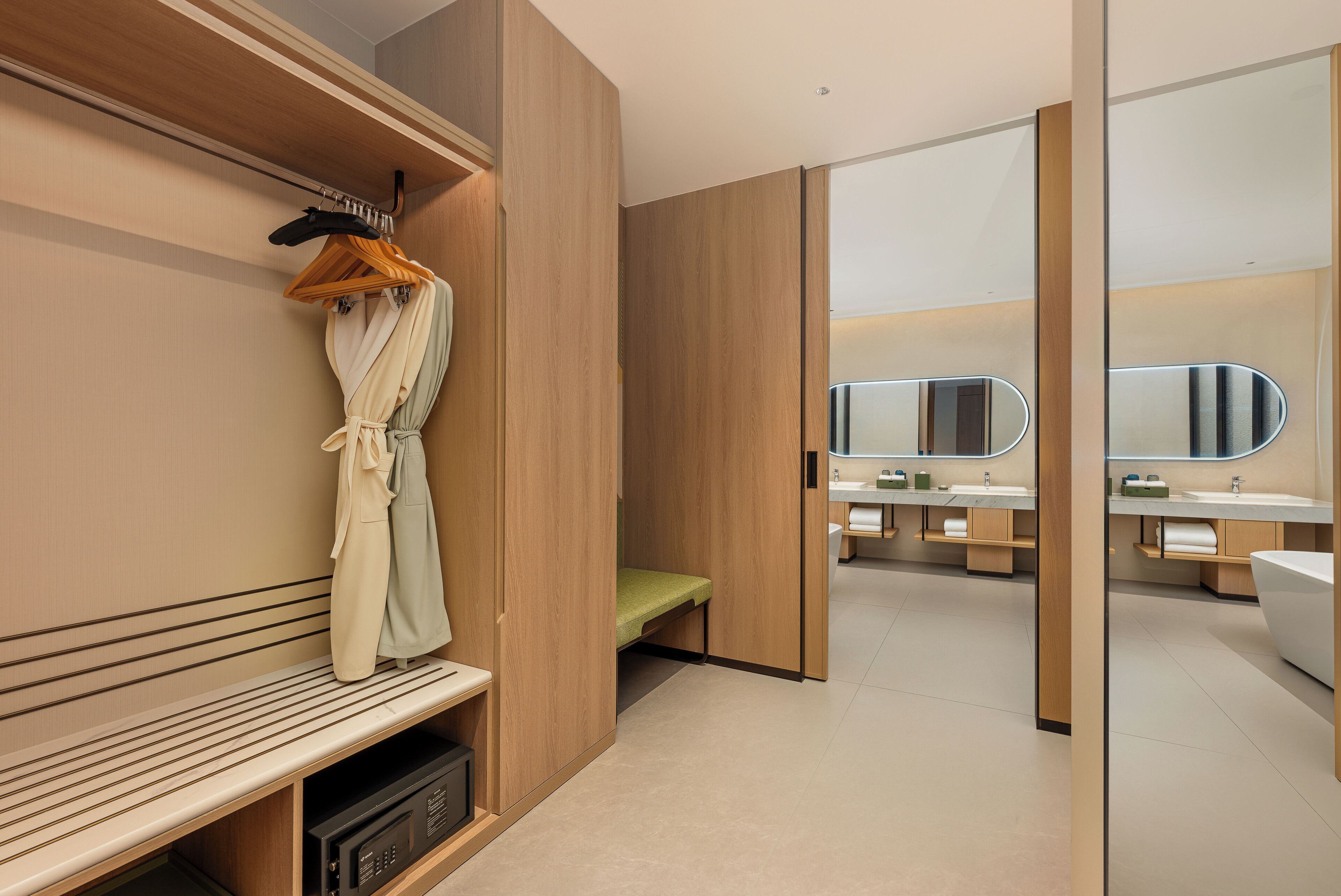 A modern bathroom with wooden paneling, a bench, a mirror, and a vanity with a sink.
