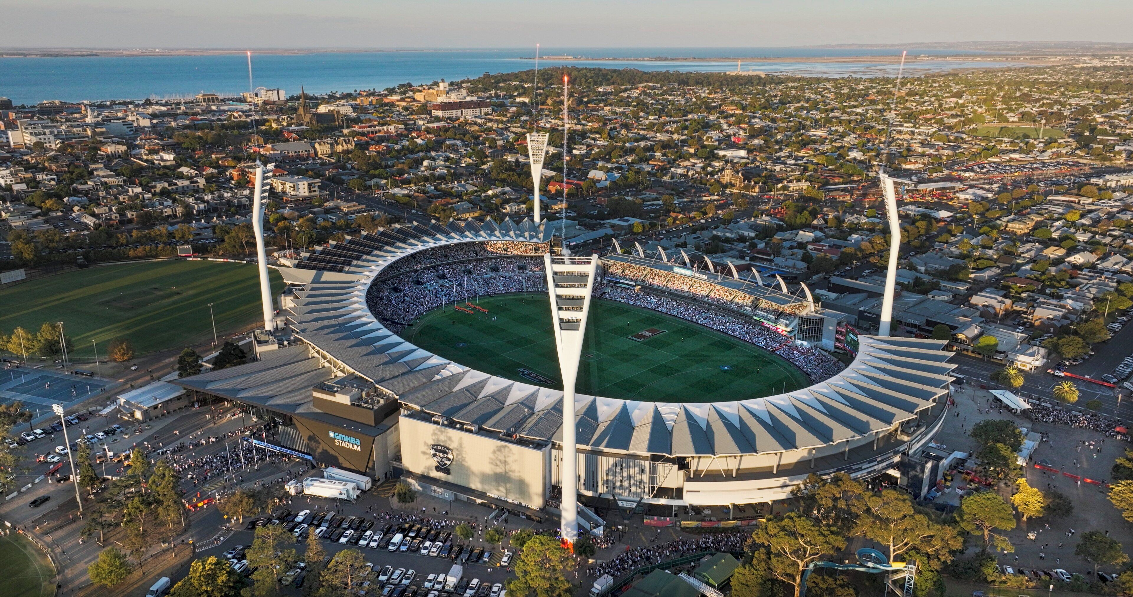 A stadium with a large seating capacity, surrounded by a densely populated urban area.