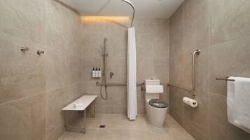 Een moderne badkamer met douche, toilet en bankje.