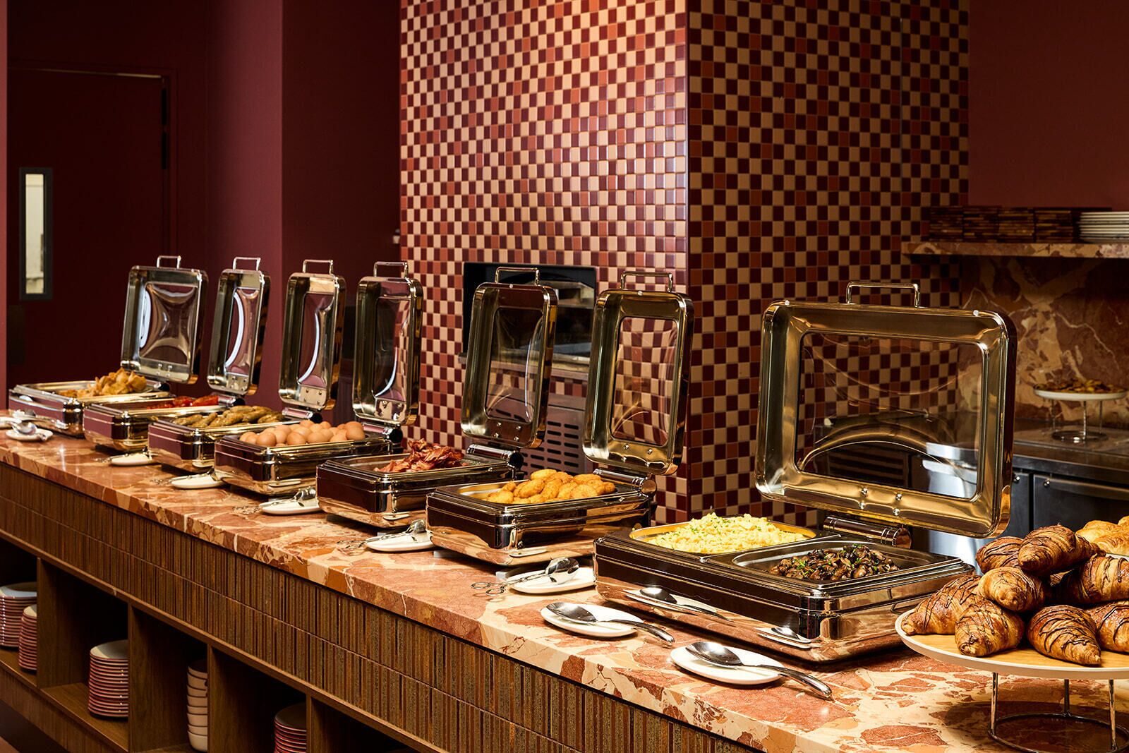 Buffet com diversos alimentos e utensílios.