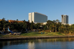 A modern building with a flat roof and a water body in the foreground.