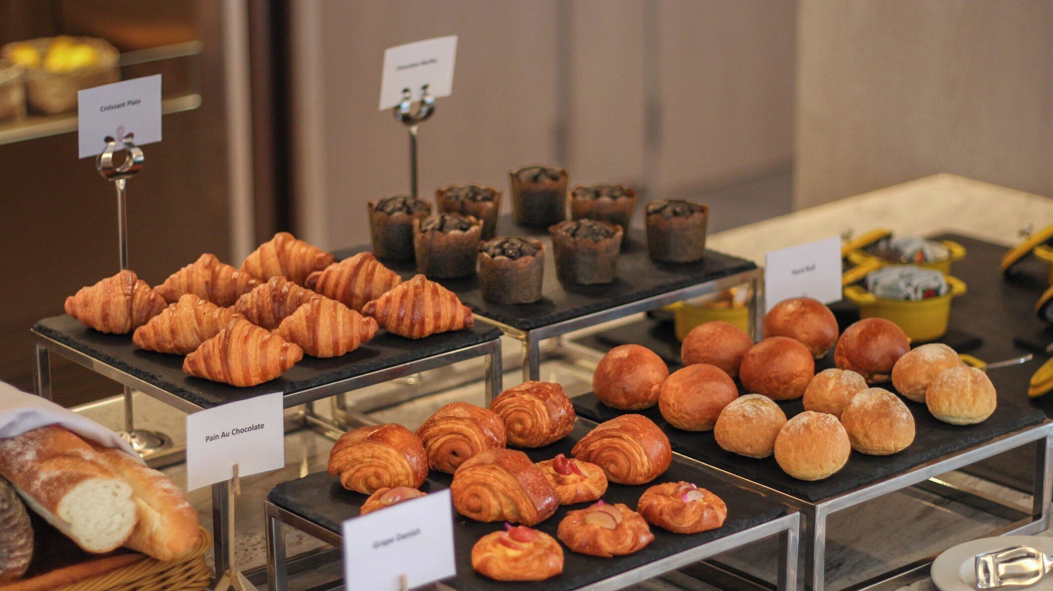 A bakery display with various pastries and bread.
