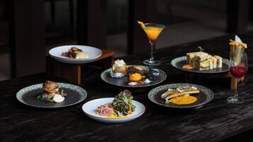 Una mesa con diversos platos y una bebida, probablemente en un restaurante.