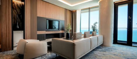 Un salon moderne avec un canapé, un téléviseur et une grande fenêtre donnant sur un beau paysage.