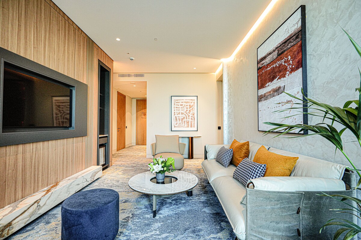 Un salon moderne avec un canapé, une table basse et un téléviseur.