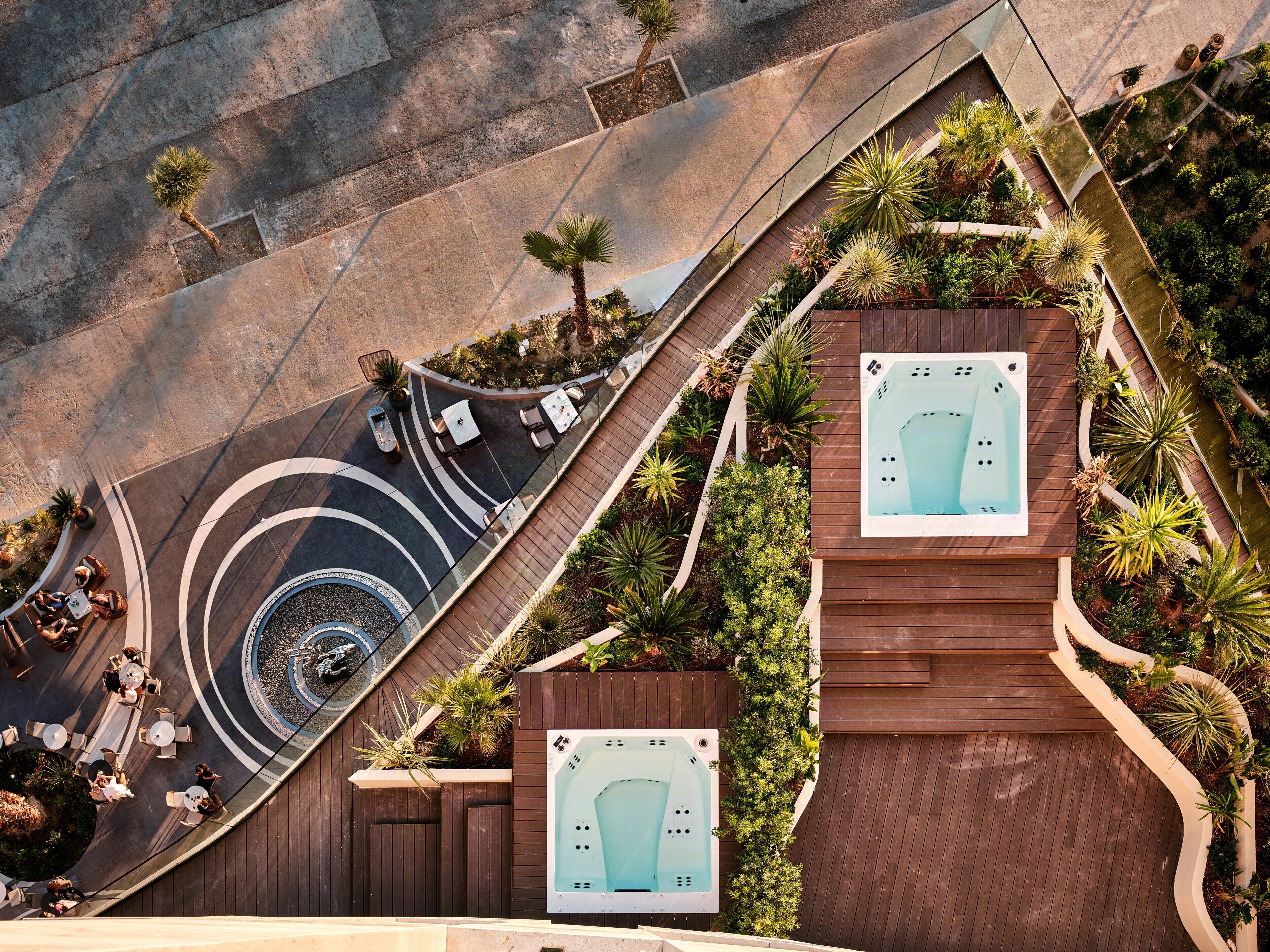 A rooftop with a hot tub, outdoor seating, and a spiral staircase.