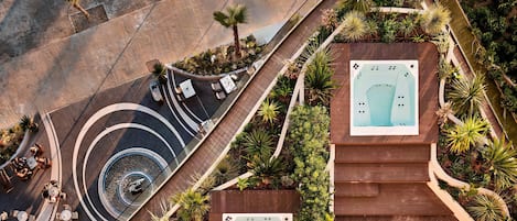 A rooftop with a hot tub, outdoor seating, and a spiral staircase.